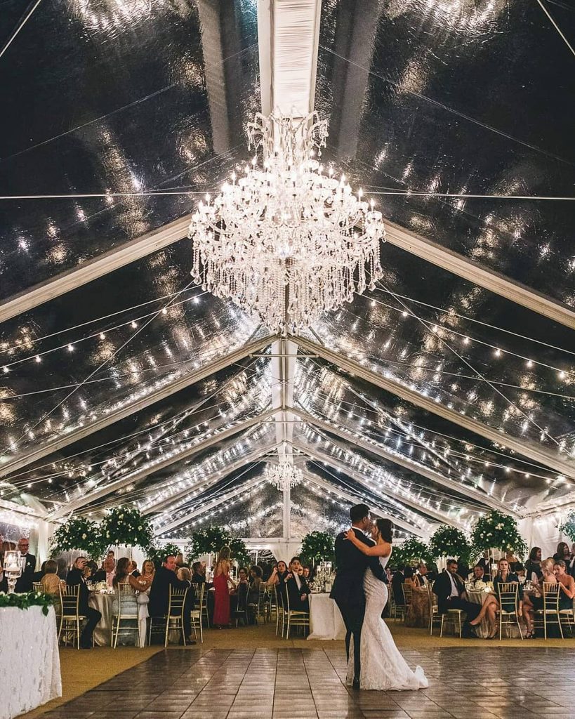 bride and groom during their first dance under a chandelier