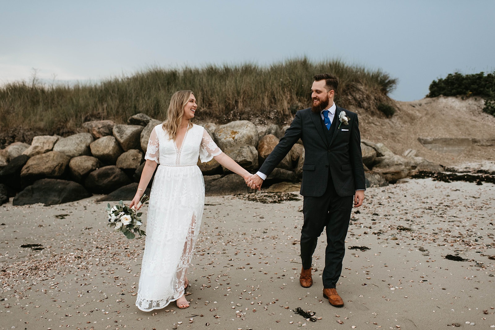 bride and groom walking on beach
