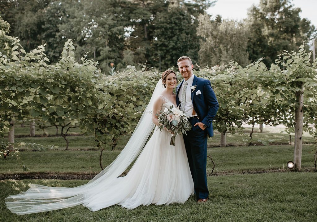 a bride and groom portrait in a field